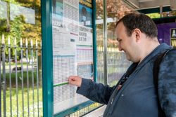 A man reading a bus timetable