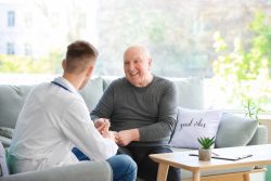 Doctor examining senior man in nursing home