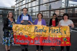 Group holding up a People First banner Group holding up a People First banner